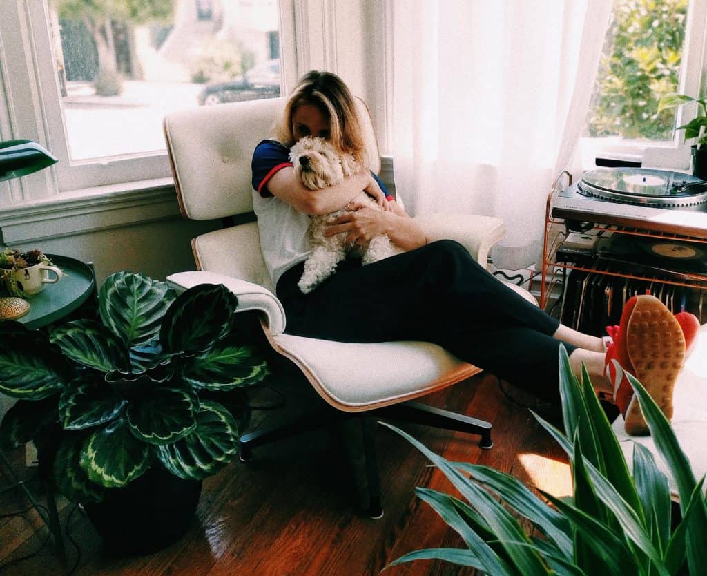 san francisco apartment potted house plants girl woman with small dog in eames lounge chair