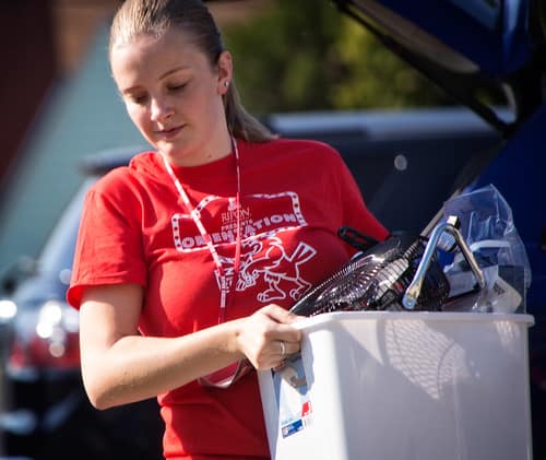 college student girl moving in stuff in a box on moving day