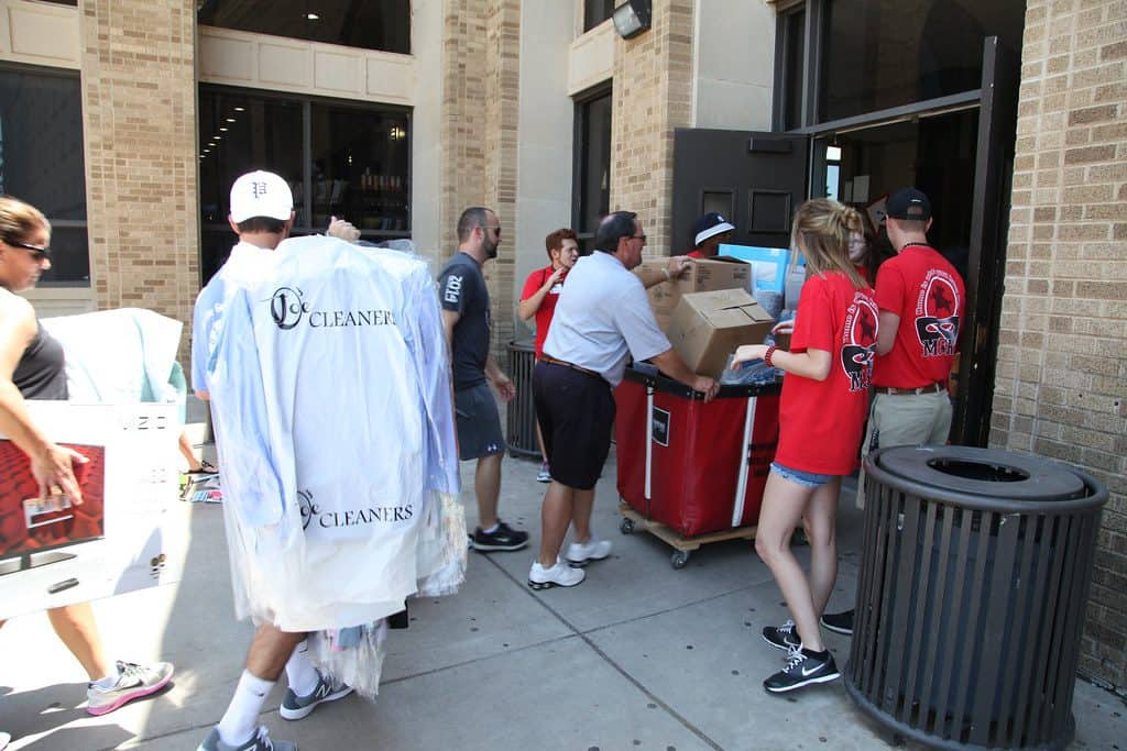 college students moving in boxes of stuff carrying clothing