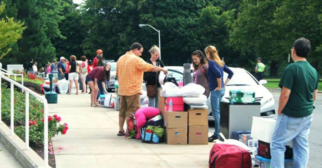parents with college students on moving day with boxes of stuff