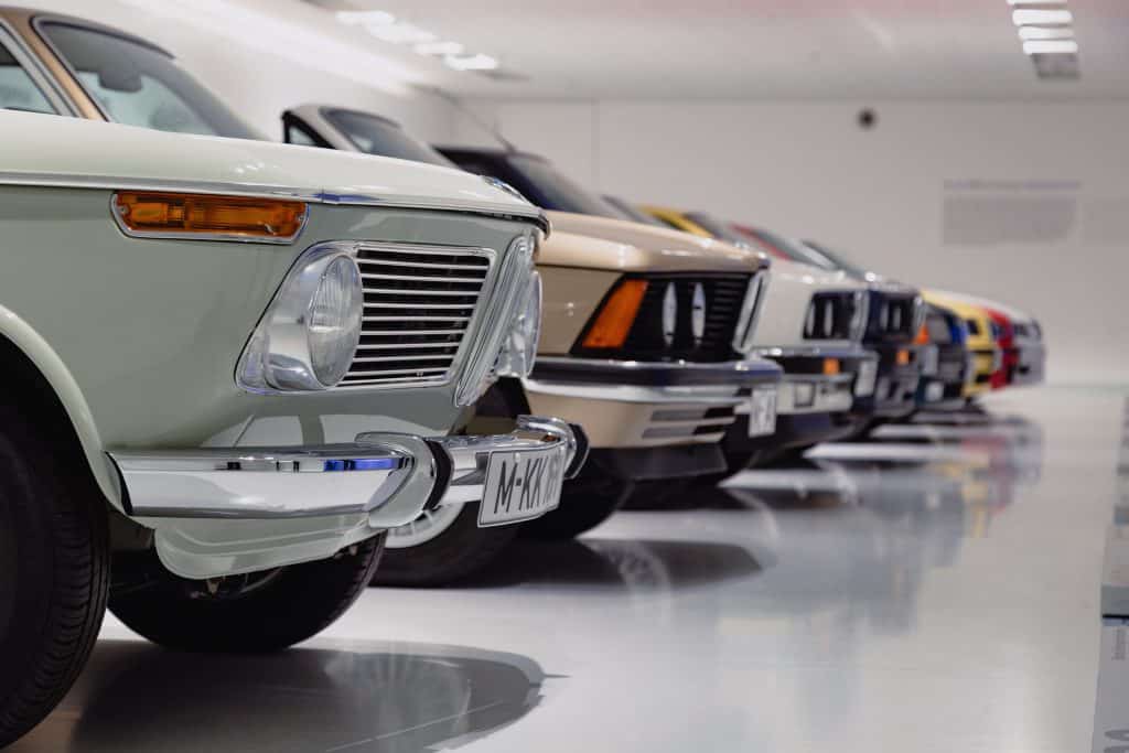 row of vintage cars parked inside indoor car storage