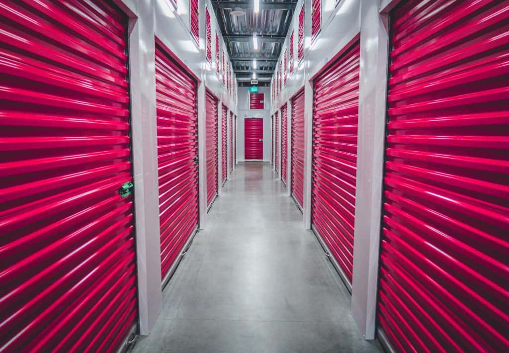 indoor self storage facility hallway with red storage unit doors