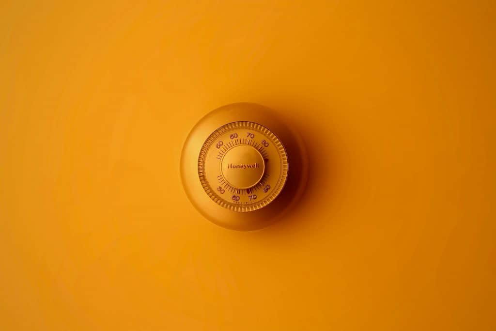 yellow thermostat on yellow wall climate control