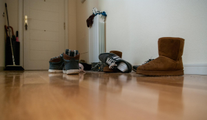 shoes-scattered-on-wooden-floor-near-entry-sneakers-ugg-boots