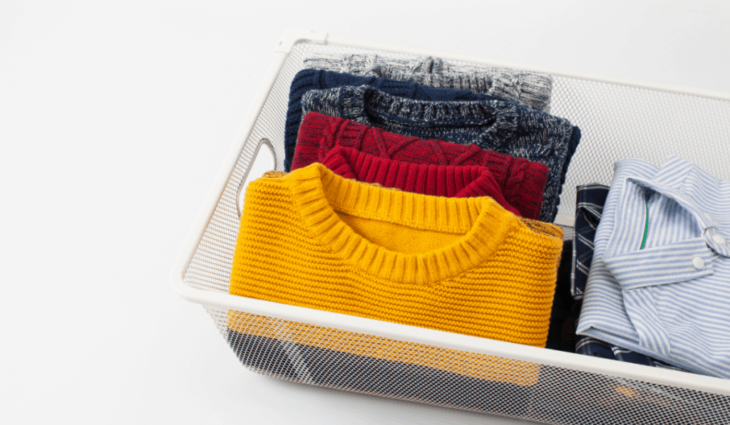 sweaters and button down shirts folded in basket