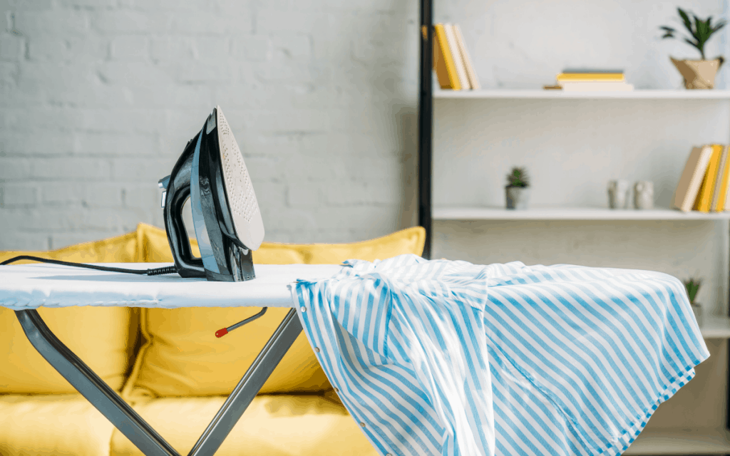 ironing board with iron and striped shirt in living room