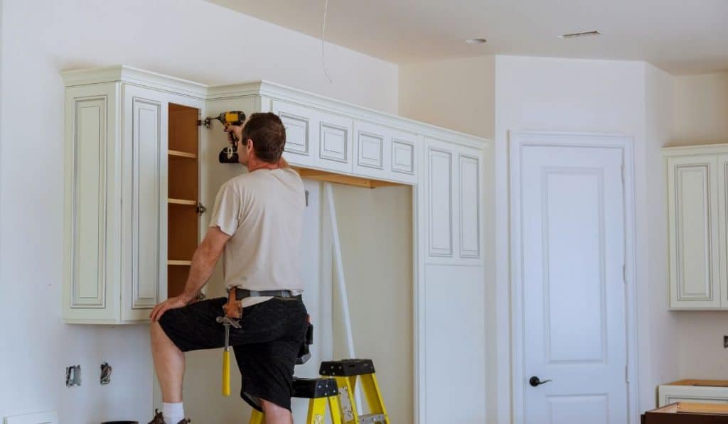 man fixing the cabinet